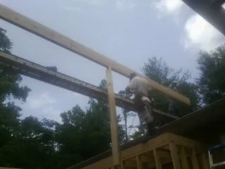 Carpenter setting a ridge beam over a new addition frame — Ice Dam Removal by Roofing Brothers in La Crosse