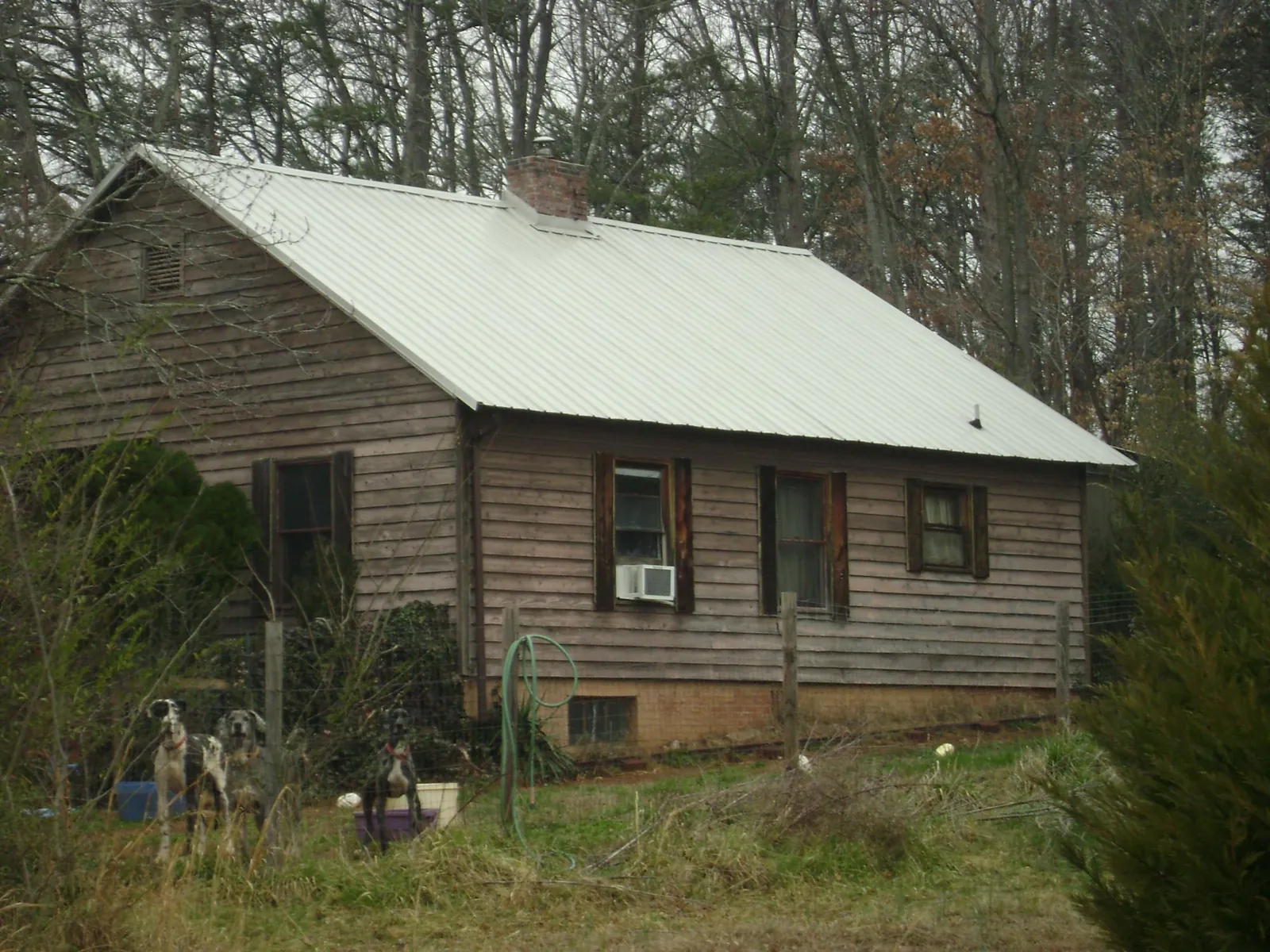 White metal roof on an old wood sided farmhouse, from a Metal Roof Installation job in La Crosse